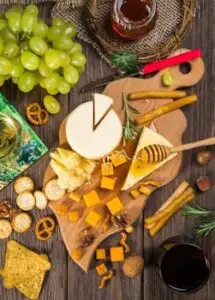pexels-photo-302457-302457 A delicious assortment of cheeses, crackers, and grapes on a wooden board for a gourmet appetizer.