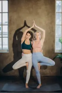 pexels-photo-3822120-3822120 Two women in yoga poses indoors promoting fitness, support, and wellness.